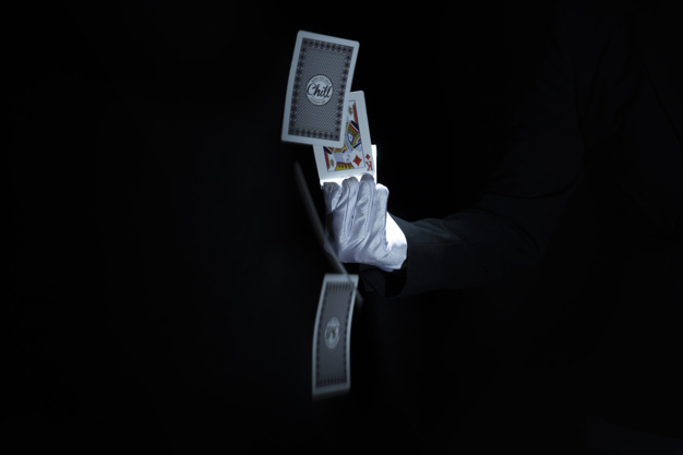 close-up-magician-s-hand-throwing-playing-cards-against-black-background_23-2147880769.jpg