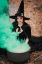 black-witch-sits-in-front-of-cauldron-from-which-green-smoke-is-falling-sorceress-conjures-brews_t20_Yw7K9m~8.jpg